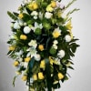 Tall yellow and white standing spray with roses, lilies, mums and dark green ribbon on an easel