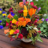 Colorful mixed bouquet in a white vase with roses and lilies