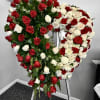 Heart-shaped standing spray of red and white roses on an easel
