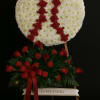 Baseball-themed white and red standing funeral spray on an easel with a red rose accent spray
