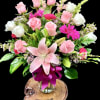 Pink and white rose bouquet with a large pink lily in a glass vase