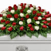 Red and white roses arranged on a white casket
