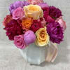 Mixed bouquet of pink, purple, and yellow roses in a wrapped base