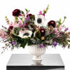 Large mixed floral arrangement in a white pedestal vase