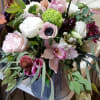 Mixed bouquet of pink, white, and green flowers in a metal vase