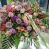 Large pastel floral spray with roses and orchids on a stand