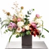 Mixed floral arrangement in a dark square vase with pink, white, and burgundy blooms
