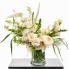 Cream and white floral arrangement in a clear glass vase