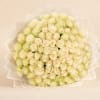 Large bouquet of cream and pale yellow roses wrapped in translucent paper