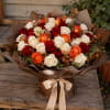 Bouquet of red, white, and orange roses wrapped in brown paper with a satin ribbon