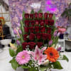 Basket arrangement of red roses with pink lilies and gerbera daisies