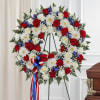 Heart-shaped funeral wreath of red and white roses with white daisies on an easel