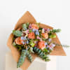 Peach roses and pastel flowers wrapped in brown paper