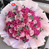 Bouquet of pink and hot pink roses wrapped in pale pink paper