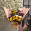 Mixed bouquet with sunflowers, gerbera daisies, and carnations in pink wrap