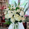 White floral bouquet in a clear glass vase with a ribbon