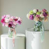 Two bouquets of carnations in glass vases with ribbon ties