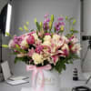 Soft pink and cream lilies rising above a cloud of roses and