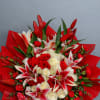 Bouquet of red and white roses with pink lilies wrapped in red paper