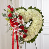 Heart-shaped floral wreath with red roses, white mums, and lilies