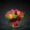 Colorful mixed flower arrangement in a glass bowl vase