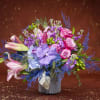 This breathtaking design showcases a variety of flowers including purple lipstick roses