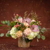 A blend of soft peach roses and speckled orchids, accented with pink