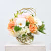 Peach roses and white orchids in a glass vase
