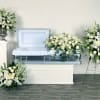 White floral funeral casket spray with matching wreaths and standing sprays