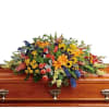 Colorful floral spray on a wooden casket