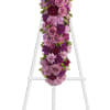 Purple and pink floral cross on a white stand
