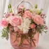 A playful cascade of soft pink roses and coral carnations spills from