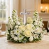 A low, rounded sympathy arrangement built around a crystal cross creates a