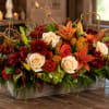 Autumn floral arrangement with roses, lilies, and mums in a wooden box