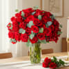 Red roses arranged in a clear glass vase with eucalyptus accents
