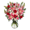 Bouquet of pink lilies and red roses in a glass vase
