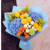 Bouquet of blue hydrangeas, yellow and orange roses, and green carnations in blue wrap