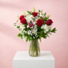 Red roses and white lilies in a clear glass vase