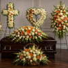 Funeral casket surrounded by white and orange floral sprays and baskets