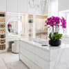 Potted purple orchids in a black planter on a marble counter