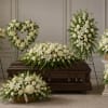 White funeral casket spray with matching standing floral tributes