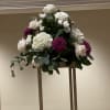 White and purple floral arrangement on a tall stand