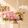 Pastel pink and white floral arrangement in a low pedestal bowl