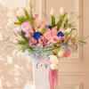 Pastel bouquet of roses, tulips, and hydrangeas in a white vase