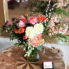 Mixed bouquet in a glass vase with pink, white, and orange blooms