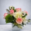 Pink-edged roses and white blooms in a square glass vase
