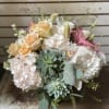 Bouquet of peach roses, white hydrangeas, pink lilies, and succulents