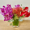 Bright orchid and anthurium arrangement in a glass vase