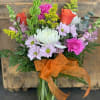 Mixed bouquet in a glass vase with orange ribbon