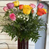 Mixed roses in a red glass vase with baby's breath